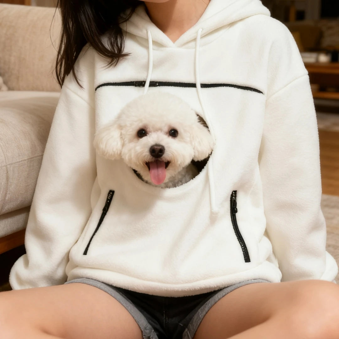 Close-up of a small dog resting in the hoodie's front pouch