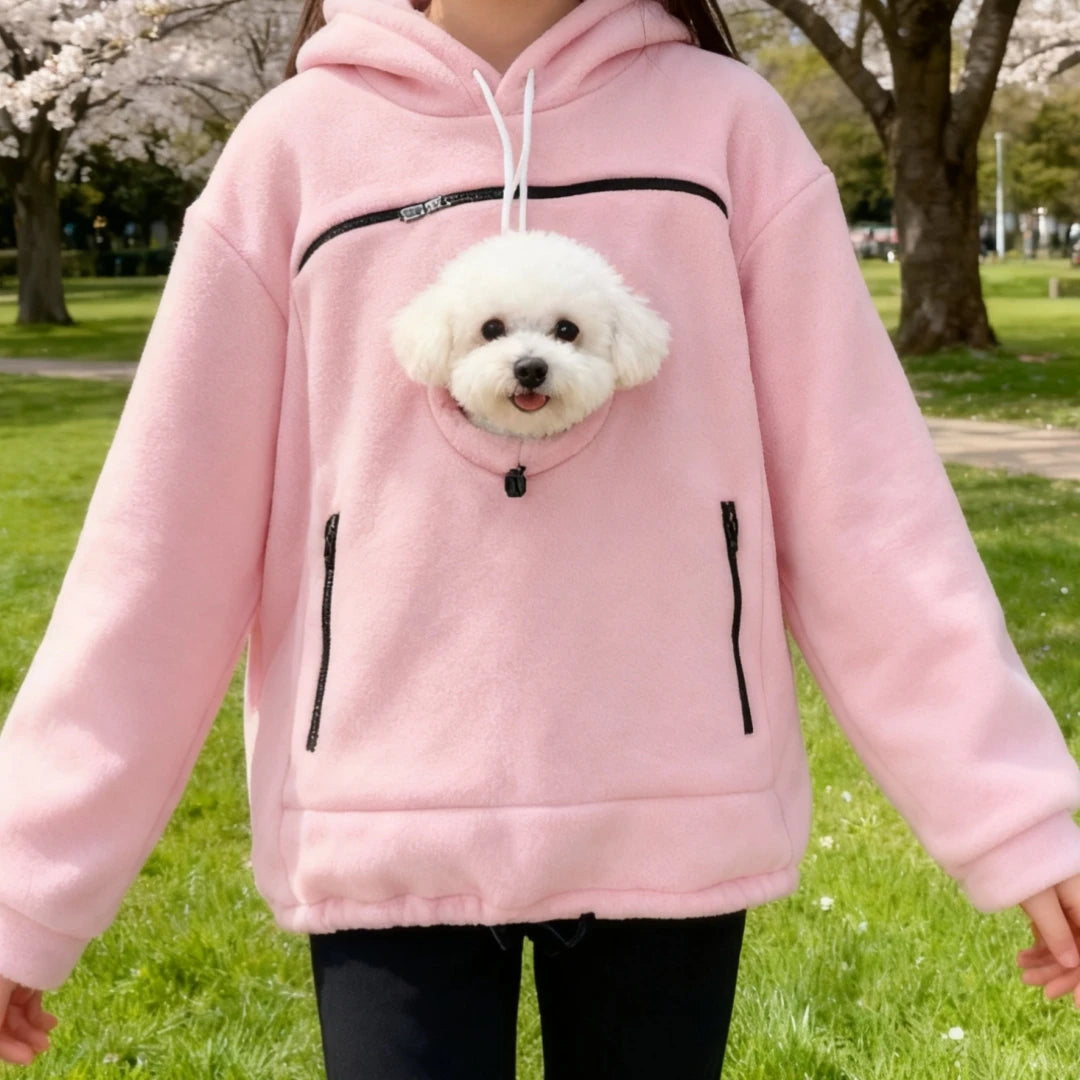 Pink pet pouch hoodie worn outdoors with a dog in the pocket